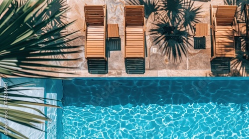 Aerial view of poolside loungers and palm shadows, capturing the serene blue waters and well-appointed sunbathing area in a tropical setting. photo