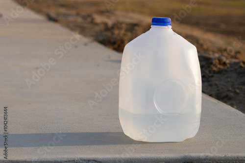 quarter full water gallon jug with blue lid