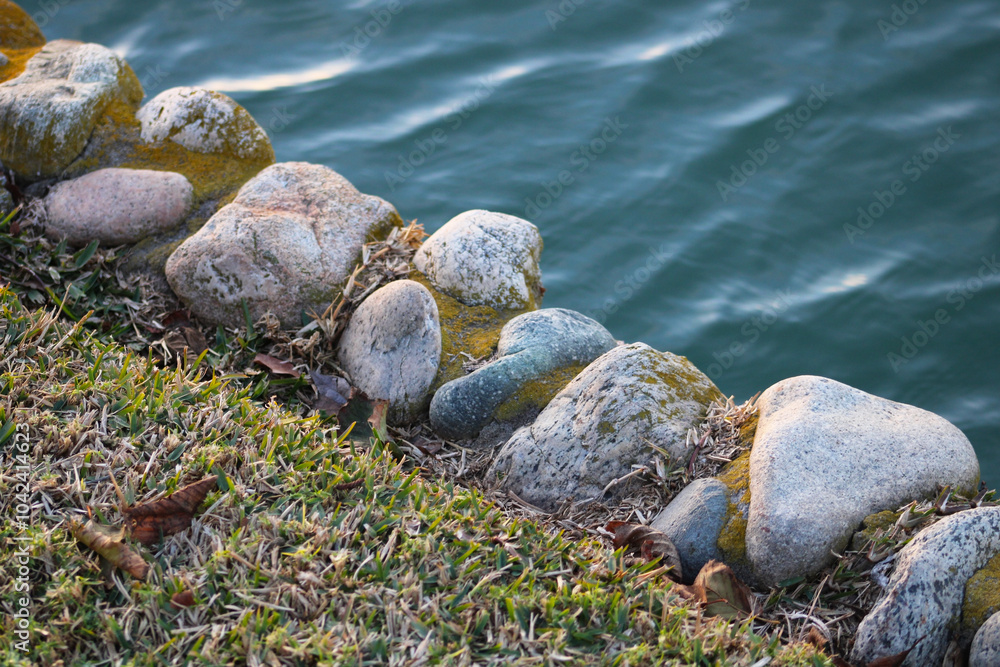 gray rocks lined next to water's edge gray rocks lined next to water's edge