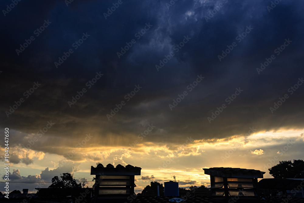 Dramatic sunset sky with dramatic clouds and silhouette of tower Dramatic sunset sky with dramatic clouds and silhouette of tower
