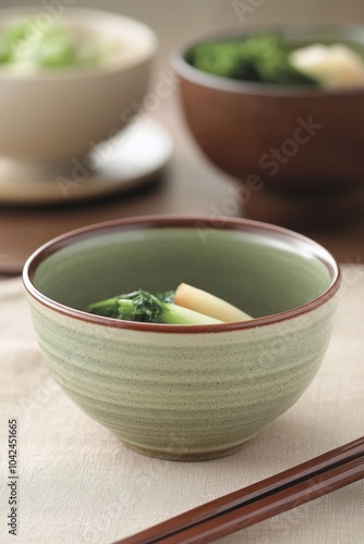 A bowl of cooked vegetables served in a simple, elegant dish.