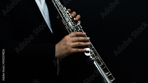 A close-up of an elegant musician passionately playing a saxophone under dramatic lighting with a black background, ideal for projects related to music, jazz culture, and live performances photo