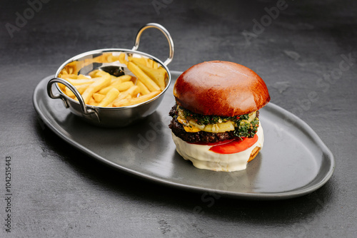 Gourmet burger with grilled pineapple, herb topping, and fries, perfect for exotic meal experience photo