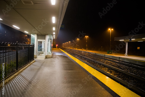 Empty railway station at night. Dramatic rainy darkness. mystical night.  without anyone, illuminated by streetlights and diffused by the fog. Concept of means of transportation. public transportation