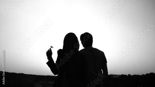 Black and white Valentine's concept with a couple and a daisy silhouette.