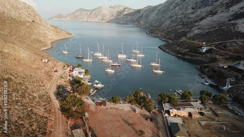 Greece,Kalimnos Island, Palionnisos Bay view high and above. Lot of boats connected to vaults at the bay, taverns at the bay and the beach is visible. photo