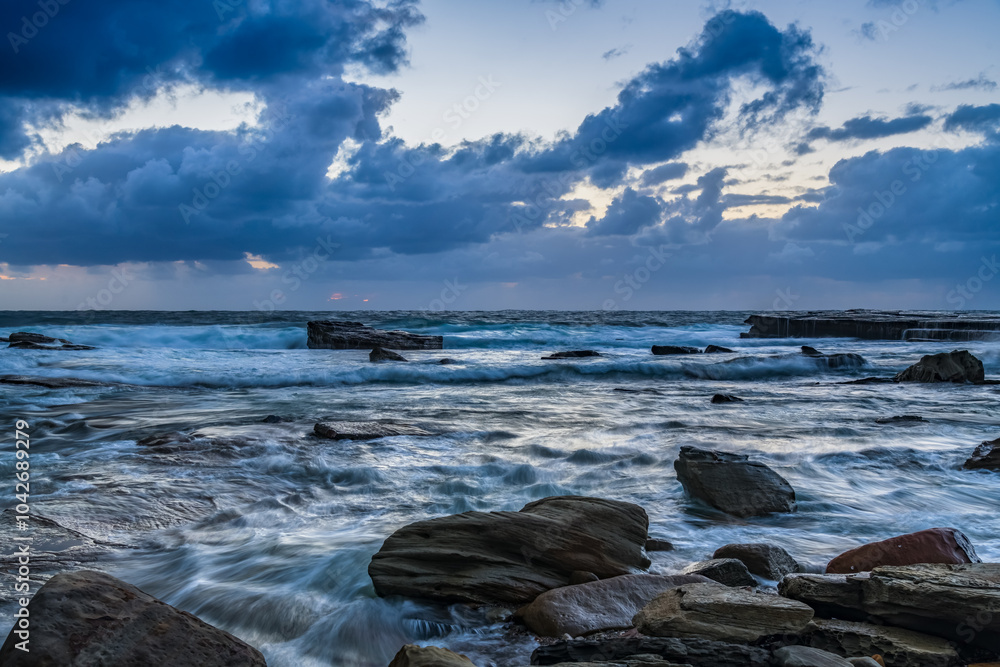 Moody sunrise seascape with clouds at the rocky inlet Moody sunrise seascape with clouds at the rocky inlet