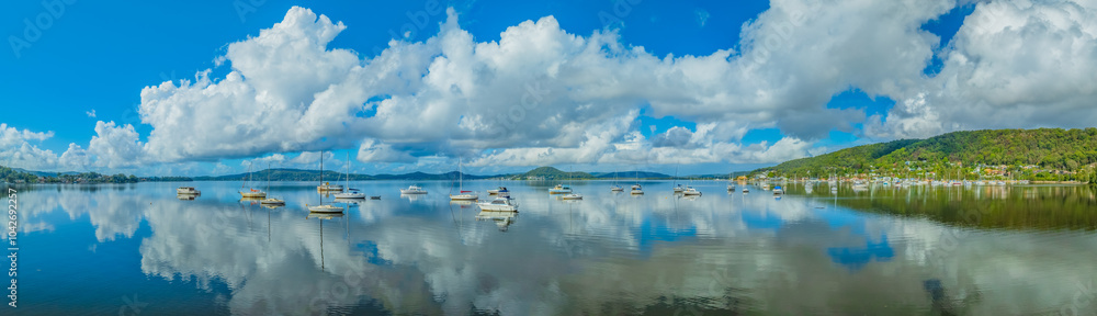 Fototapeta premium Aerial panorama over the bay with clouds, reflections and boats