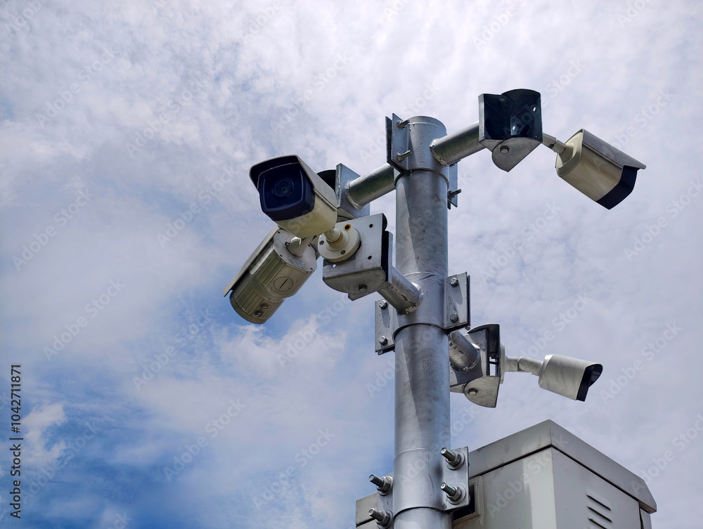 Multiple security cameras installed to ensure safety, set against a beautiful sky background Multiple security cameras installed to ensure safety, set against a beautiful sky background