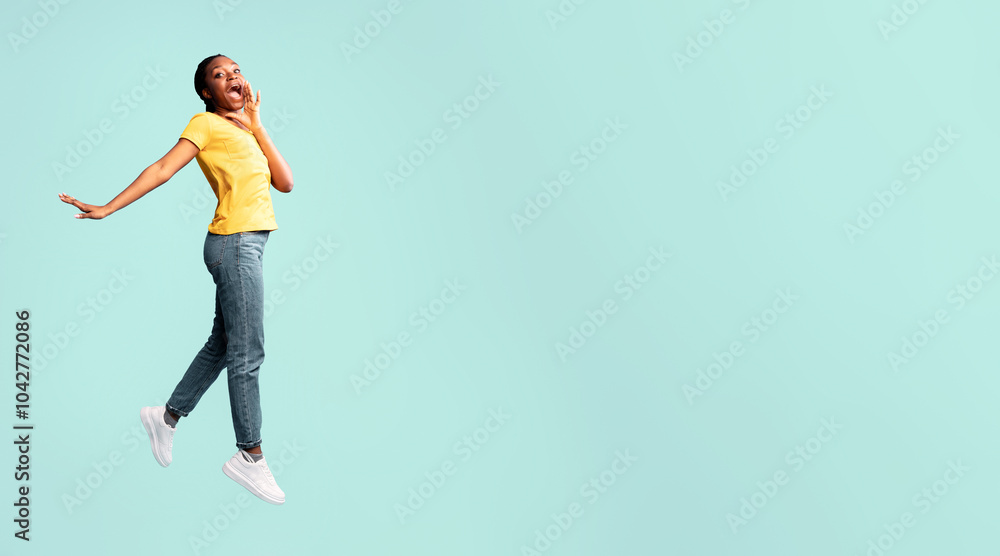 Hey. Positive Black Lady Jumping Shouting Holding Hand Near Mouth Over Blue Studio Background. Copy Space Hey. Positive Black Lady Jumping Shouting Holding Hand Near Mouth Over Blue Studio Background. Copy Space