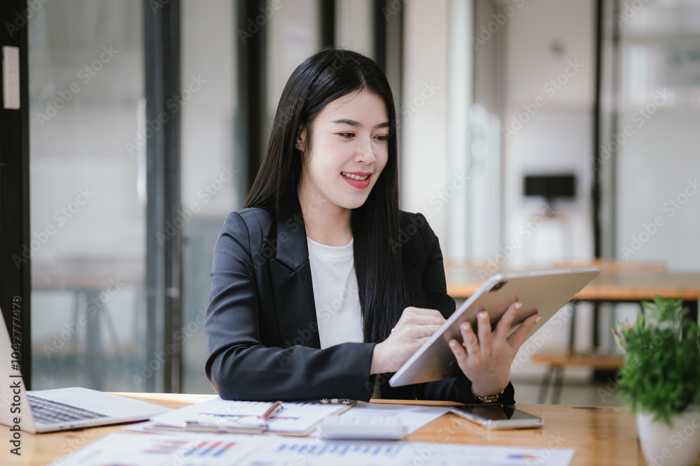 Freelance Asian businessman working independently using tablet computer in modern office. Accounting analysis report, real estate investment information, financial and tax concept. Freelance Asian businessman working independently using tablet computer in modern office. Accounting analysis report, real estate investment information, financial and tax concept.