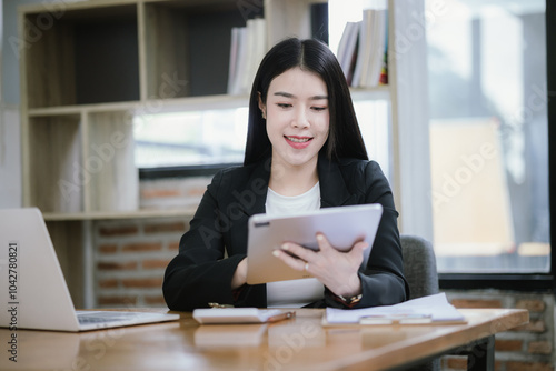 Asian woman using calculator to calculate financial expenses in home office. Pressing calculator button to analyze finances, electronic payments.