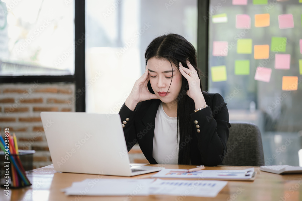 Image of Asian businesswoman working with laptop in home office. Beautiful woman sitting at desk, laptop, smartphone and documents on table. Image of Asian businesswoman working with laptop in home office. Beautiful woman sitting at desk, laptop, smartphone and documents on table.