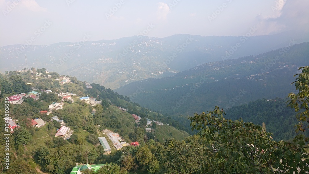 Fototapeta premium View of village in the hills from top with layers of mountains