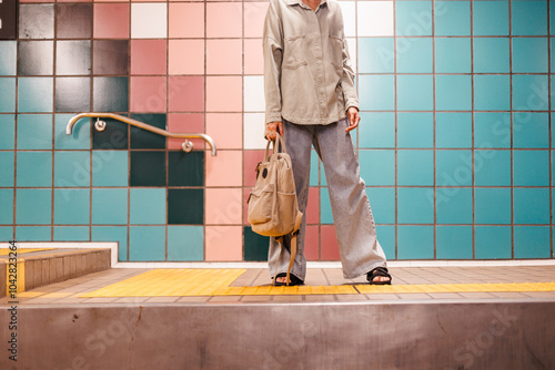 girl with bag waiting for train at station. wait for train. girl in subway. young girl in stylish clothes and with bag in subway. fashionable bag close-up.