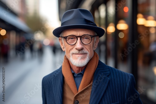 Portrait of a senior man with hat and glasses in the city.