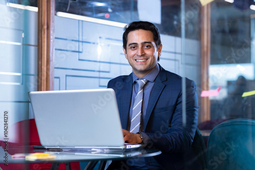 Canvas Print Successful businessman in modern office working on laptop