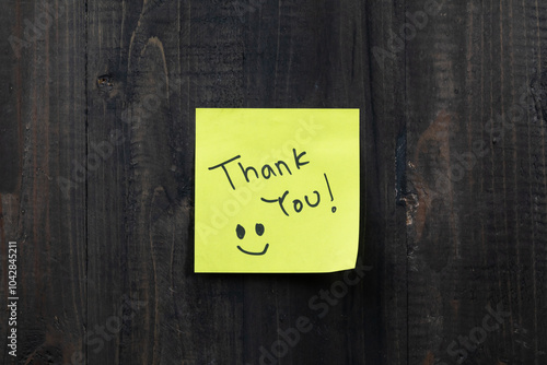 Positive idea concept image using a wooden table and a sticky note with the words Thank you