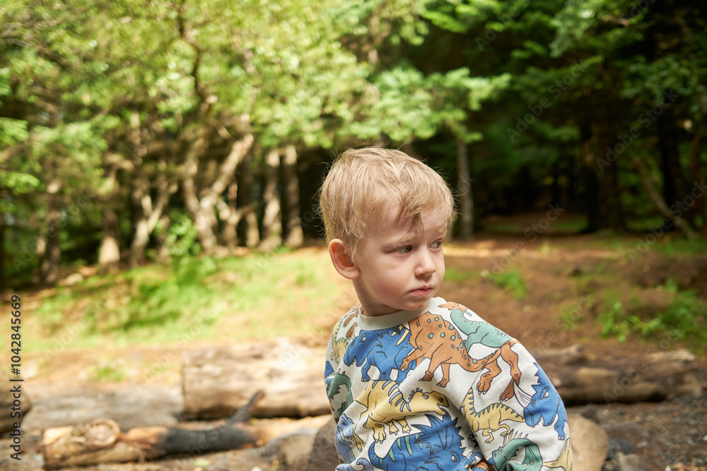 Boy standing near wooden logs trees Boy standing near wooden logs trees