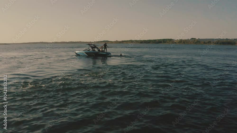 A motor boat on the water against the evening sun. Wakeboarding classes. Wakeboarding A motor boat on the water against the evening sun. Wakeboarding classes. Wakeboarding