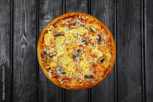 Pizza with mushrooms and cheese, top view, on black wooden background.