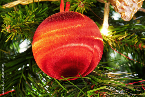 Red Christmas toy on a Christmas tree green branch. 2025 New Year background photo