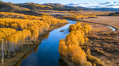 A scenic view of golden autumn trees lining a winding river, reflecting the vibrant colors of the season.