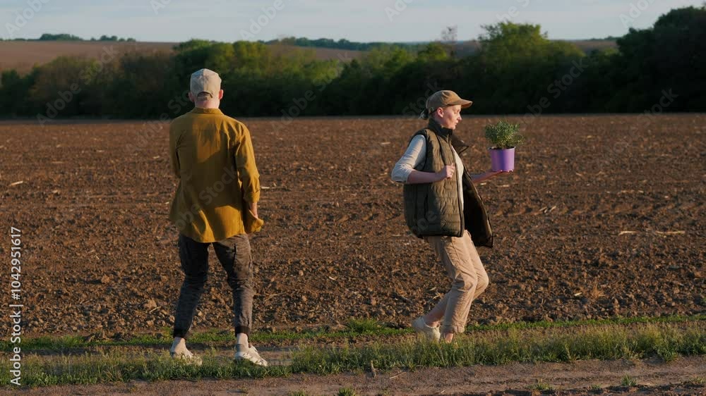 Dancing joyfully from a side angle are two farmers - a man holding a ...