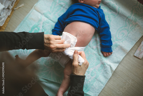 Wallpaper Mural Directly above shot of senior woman tying reusable diaper for grandson lying down at home Torontodigital.ca