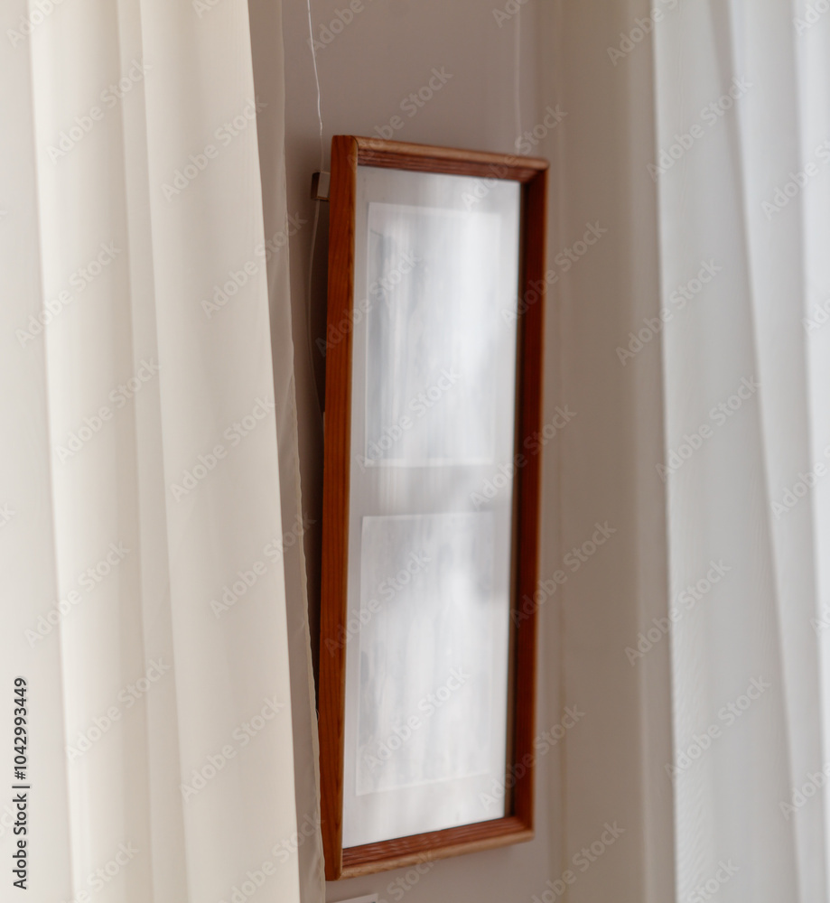 A wooden framed picture hangs on a wall A wooden framed picture hangs on a wall