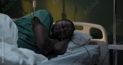 African patient peacefully asleep in hospital room.