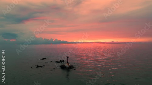 A beautiful sunset over a tranquil body of water with a boat in the foreground