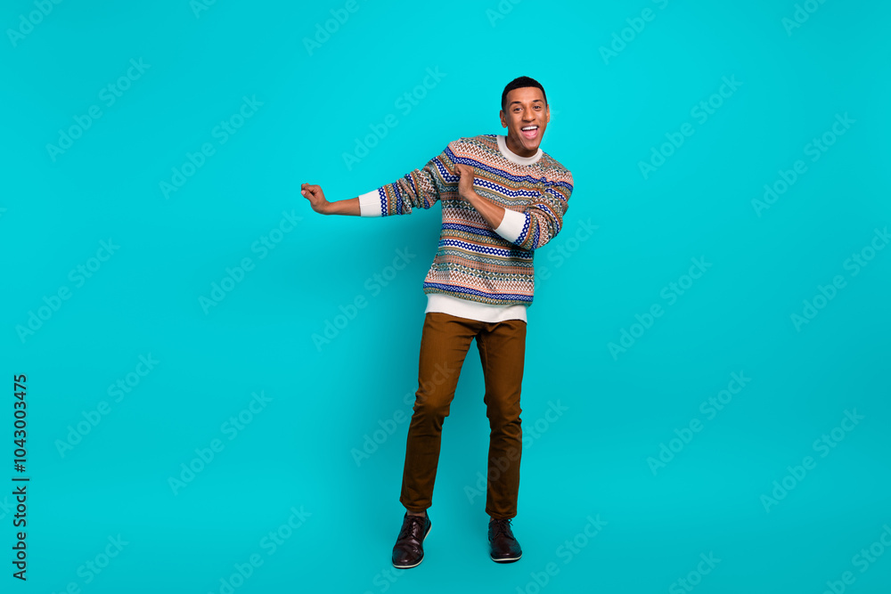 Full size photo of nice young man dancing wear sweater isolated on teal color background Full size photo of nice young man dancing wear sweater isolated on teal color background