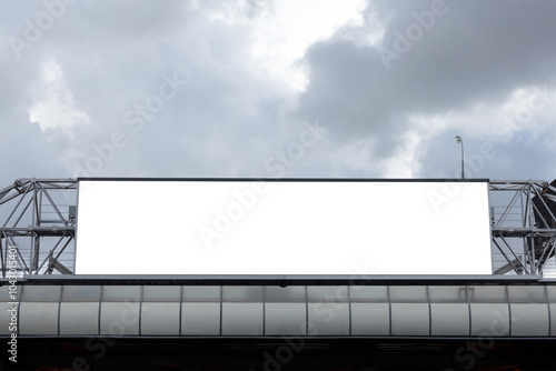 Horizontal blank billboard on metal truss structure on cloudy sky background. Mock-up.