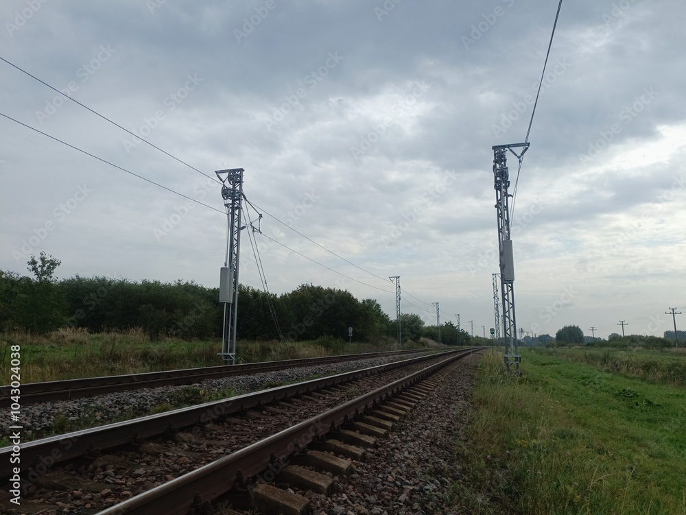 Two way railroad tracks in countryside. Two railway tracks. Cloudy day. Countryside. Fields and trees. Two way railroad tracks in countryside. Two railway tracks. Cloudy day. Countryside. Fields and trees.