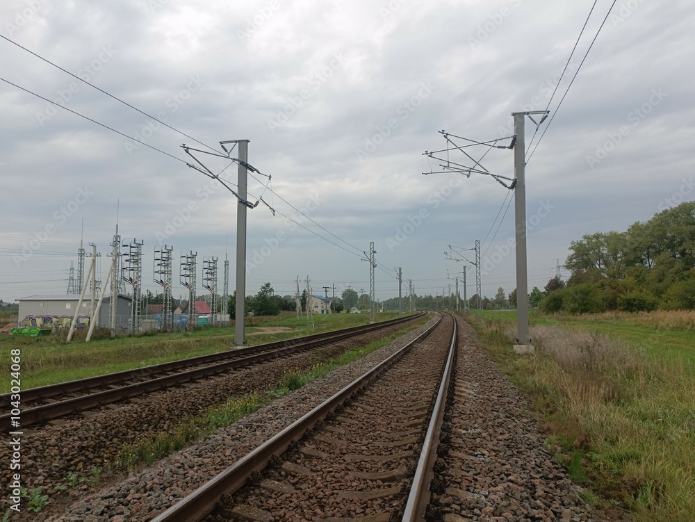 Two way railroad tracks in countryside. Two railway tracks. Cloudy day. Countryside. Fields and trees. Two way railroad tracks in countryside. Two railway tracks. Cloudy day. Countryside. Fields and trees.