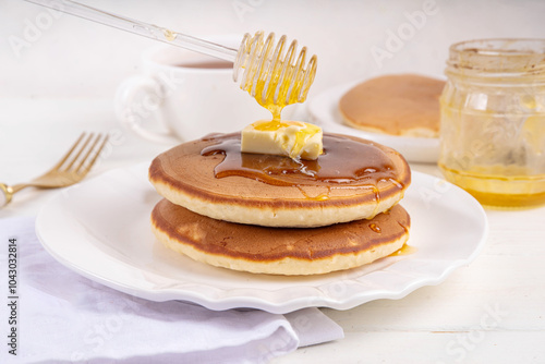 Pancakes with butter and honey or maple syrup drizzles photo