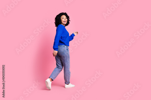 Full length body photo of beautiful model young woman wearing trendy apparel walking away alone isolated on pink color background