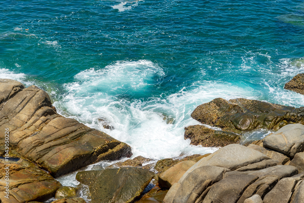 Waves crashed onto the shore with large rocks. Waves crashed onto the shore with large rocks.