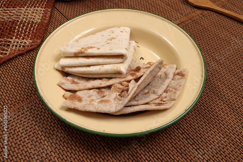 South east Asian Indian Pakistan Bangladesh staple Wheat flower flatbread chapati tandoori roti on rustic metal tin plate brown mat background photo