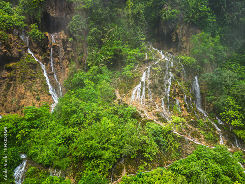 A stunning waterfall located in the center of a lush green forest