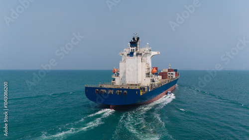 Aerial top view over international containers cargo ship at industrial import-export port prepare to load containers with big container loader ship vessel. global transportation and logistic business