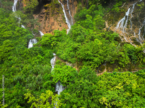 A stunning waterfall located in the center of a lush green forest