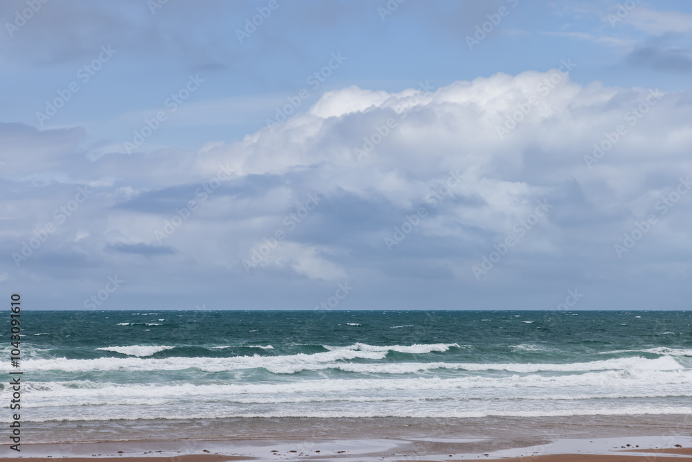 Vibrant blue sky with fluffy clouds over the deep green sea at Strandhill, Ireland, showcasing the vivid colors of the ocean and sky Vibrant blue sky with fluffy clouds over the deep green sea at Strandhill, Ireland, showcasing the vivid colors of the ocean and sky