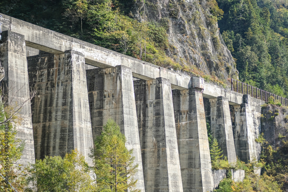 Kurobe Dam, Tateyama, Toyama, Chubu, Japan A rugged, concrete dam structure stands against a lush, mountainous backdrop, nature and engineering. Kurobe Dam, Tateyama, Toyama, Chubu, Japan A rugged, concrete dam structure stands against a lush, mountainous backdrop, nature and engineering.