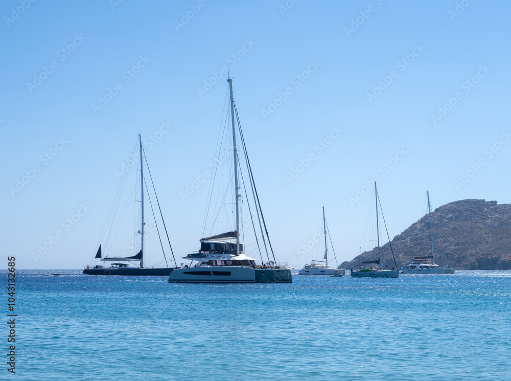 Beautiful yachts and catamarans in the Mediterranean Sea on the island of Mykonos in Greece Beautiful yachts and catamarans in the Mediterranean Sea on the island of Mykonos in Greece