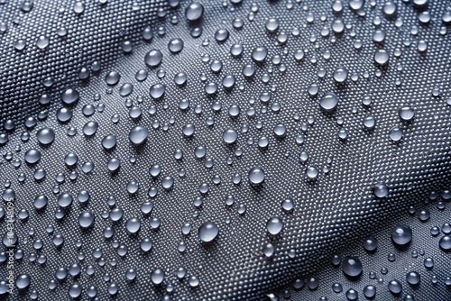 Grey ripstop nylon fabric with water drops, creating a sleek silhouette photo