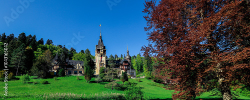 Explore the majestic Peles Castle surrounded by vibrant autumn landscapes in Romania photo