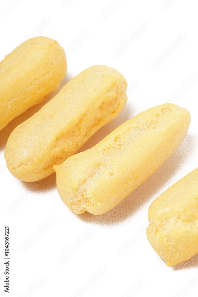 Neatly stacked mini cream puffs (sus kering) in a thumb-sized, golden-yellow shape. Photographed on a white background. Perfect as a light snack. Neatly stacked mini cream puffs (sus kering) in a thumb-sized, golden-yellow shape. Photographed on a white background. Perfect as a light snack.