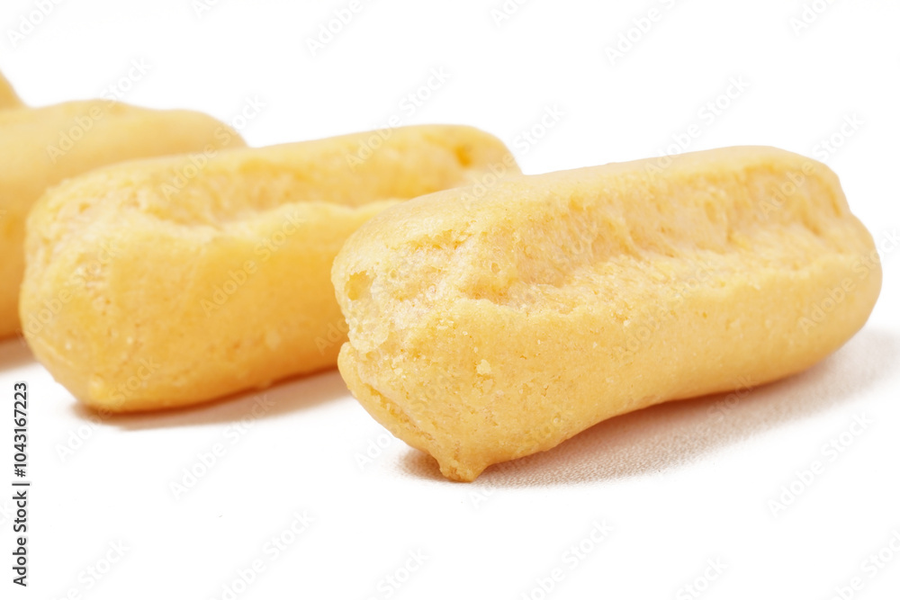 Neatly stacked mini cream puffs (sus kering) in a thumb-sized, golden-yellow shape. Photographed on a white background. Perfect as a light snack. Neatly stacked mini cream puffs (sus kering) in a thumb-sized, golden-yellow shape. Photographed on a white background. Perfect as a light snack.